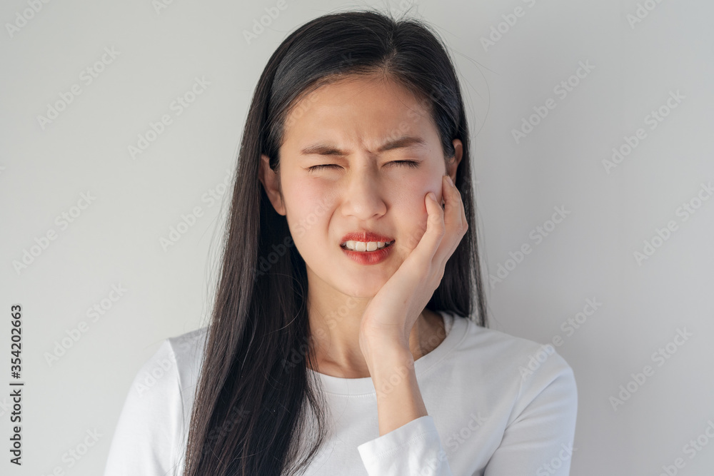 Teeth and gum problem concept. Asian young woman touching cheek and feeling toothache and pain face expression. Teeth and gum problem concept. Asian young woman touching cheek and feeling toothache and pain face expression.