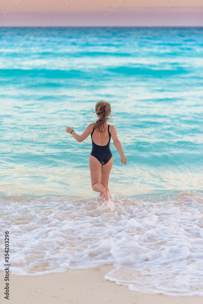 Slender blonde woman admires the sunrise at a Carribean sea. Slender blonde woman admires the sunrise at a Carribean sea.