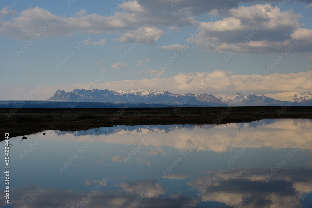 Fototapeta premium Snow covered mountains reflected in a shallow lake in Iceland