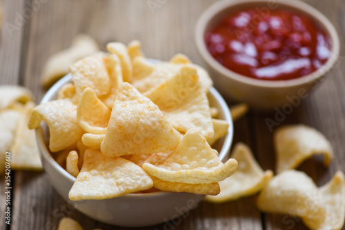 prawn crackers chips on white bowl and wooden table background - homemade crunchy prawn crackers or shrimp crisp rice and ketchup for traditional snack