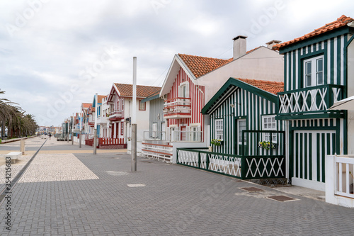 Street with colorful striped houses, Costa Nova, Aveiro, Portugal. Facades of colorful fisheman houses in Costa Nova, Aveiro, Portugal © Elena Sistaliuk