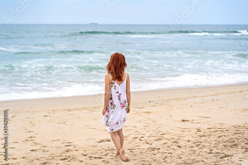 Relaxed woman enjoying ocean, freedom and life at beach. Young lady feeling free, relaxed and happy. Concept of freedom, happiness, enjoyment and well being.
