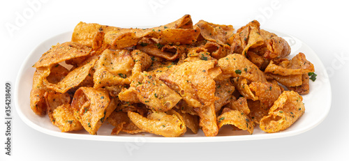 Crispy chicken skin on a white plate.