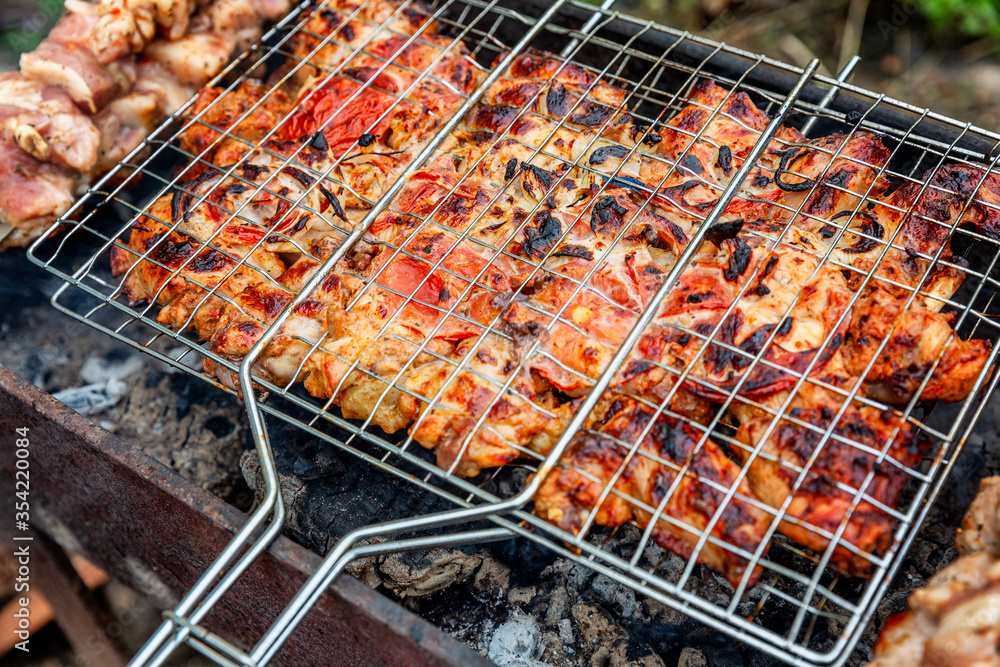The meat is grilled in a barbecue on the nature. Close-up. Outdoor activities and healthy eating.