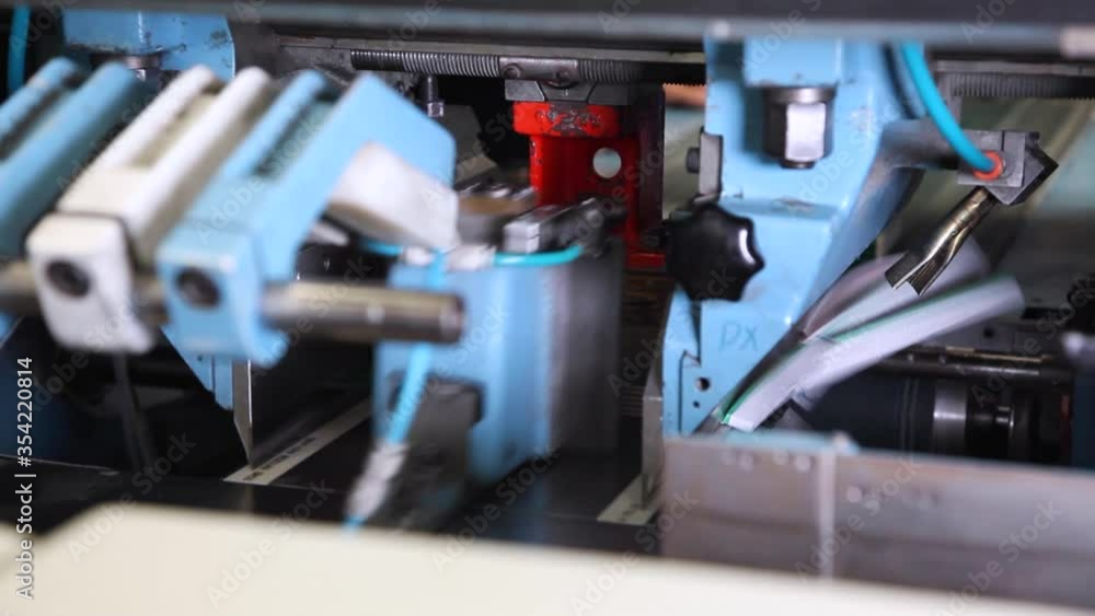 A knife is cutting off edges of a book in printing house Stock Video