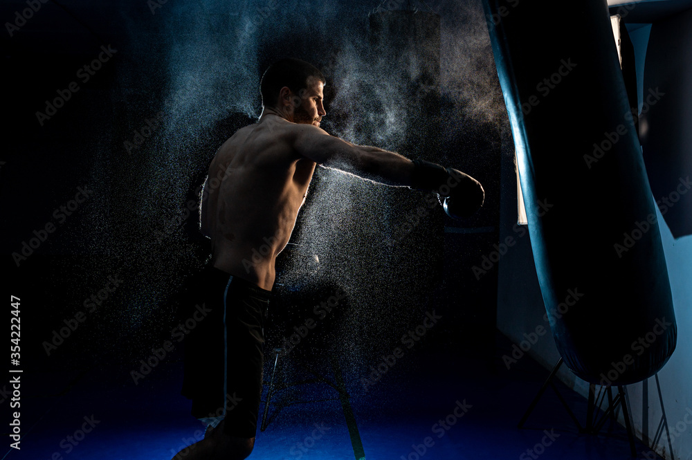 Sportsman boxer fighting on black background with smoke. Boxing sport concept. Shadow fight