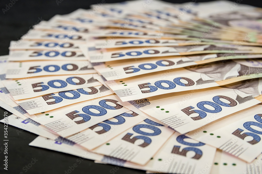 A lot of Ukrainian hryvnias, face value 500 hryvnias on a black background, nicely laid out money on black. A lot of Ukrainian hryvnias, face value 500 hryvnias on a black background, nicely laid out money on black.