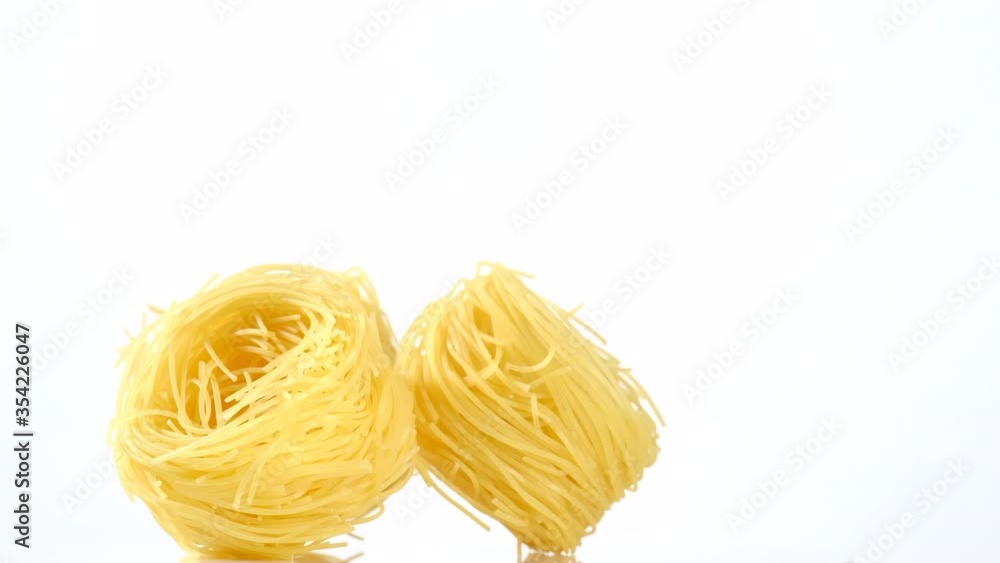 raw pasta capellini rotating isolated on white background. central composition raw pasta capellini rotating isolated on white background. central composition