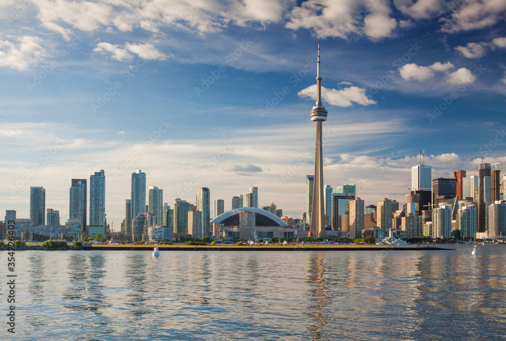 Canada - Toronto - The beautiful summer cityscape with the famous CN tower, Rogers Center (aka SkyDome) and residential apatment buildings on the lake shore taken from city islands