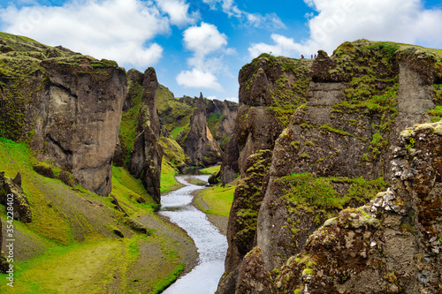 Amazing view at Fjadrargljufur Canyon is a deep canyon in the south-eastern part of Iceland. The Fjaðrá River flows through steep walls and meandering water, in summer with green grass and blue skies.