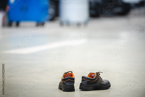 One pair of safety shoes or safety shoes of the car mechanic in the car repair shop The mechanic wears shoes for safety. The backdrop is epoxy floor for service cars. © เลิศลักษณ์ ทิพชัย