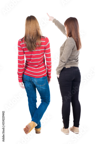 Back view of two young woman photographed on a mobile phone in sweater.