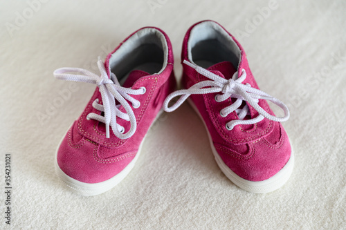 Little toddler pink leather shoes with white lace.