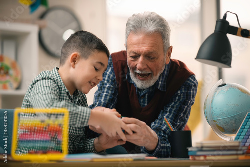 Принти на полотні Grandfather and grandson playing with rubik cube