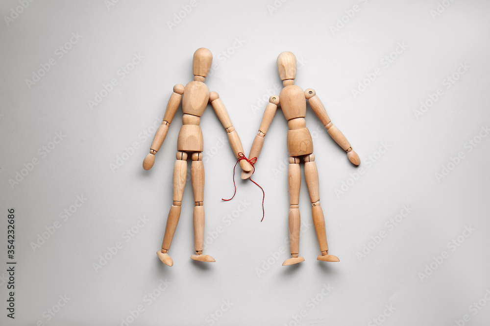 Wooden human figures holding hands on light background. Unity concept Wooden human figures holding hands on light background. Unity concept