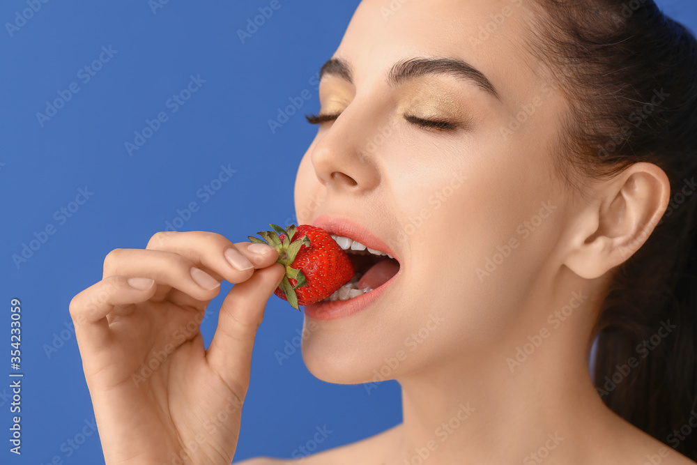 Sexy young woman with strawberry on color background Sexy young woman with strawberry on color background