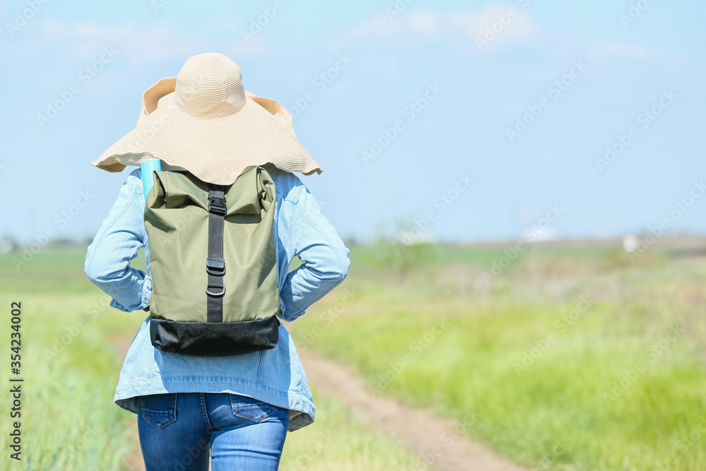 Female traveler with backpack in countryside Female traveler with backpack in countryside