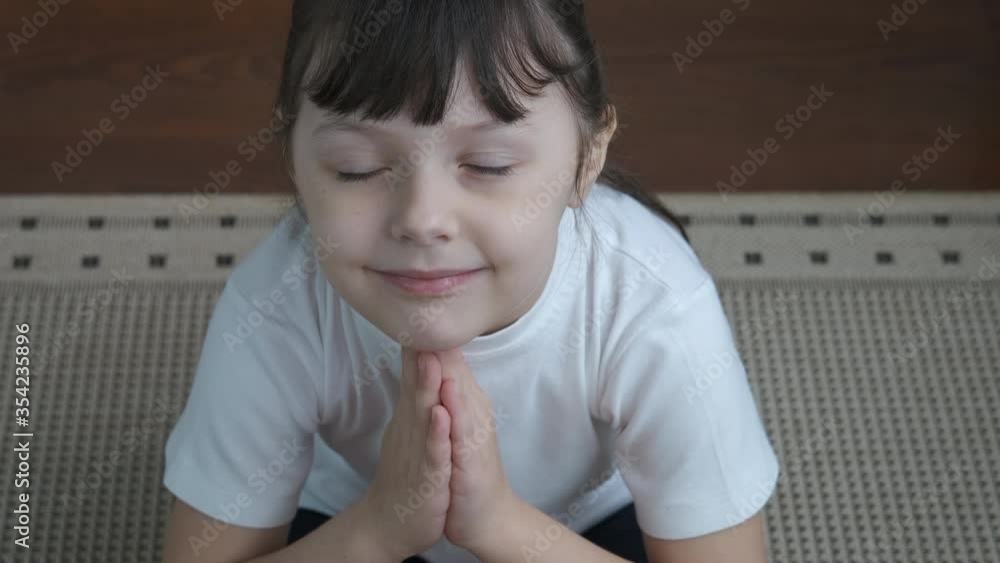 Tranquility yoga pose. Adorable little girl meditates, top view. Tranquility yoga pose. Adorable little girl meditates, top view.