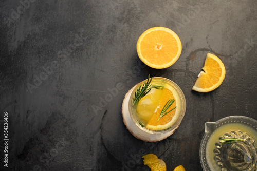 Homemade lemonade with rosemary and ice on dark concrete background.Top view photo