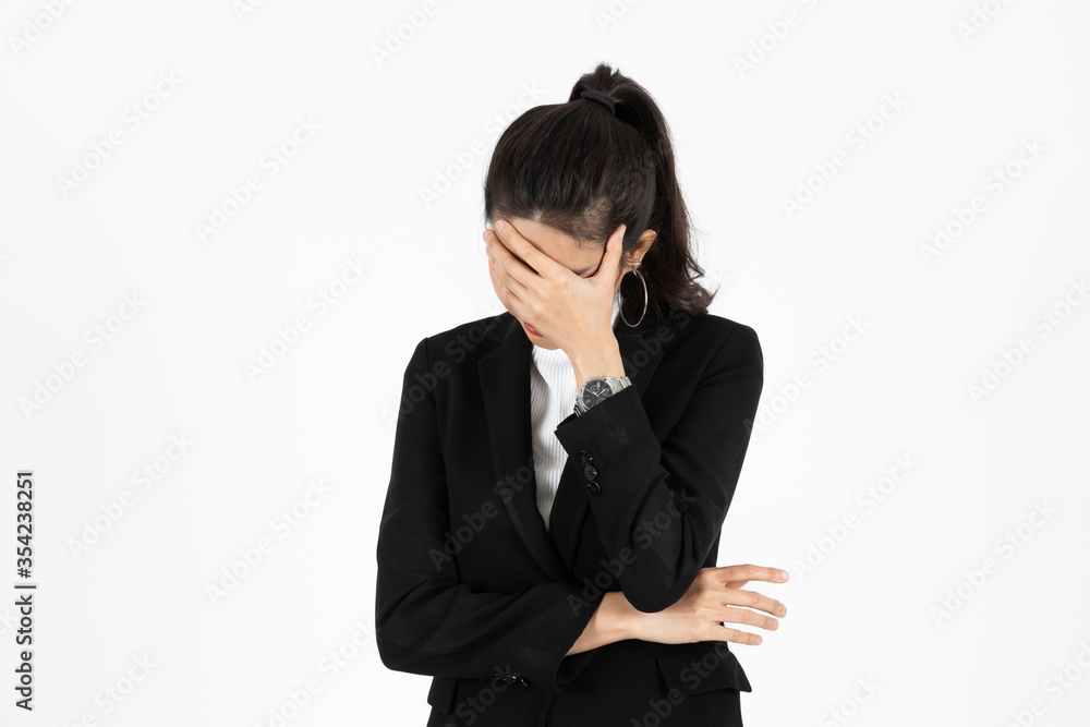 Tired overworked young Asain business woman in suit with hands on face suffering from severe depression over white isolated background. Failure and layoff concept. Tired overworked young Asain business woman in suit with hands on face suffering from severe depression over white isolated background. Failure and layoff concept.