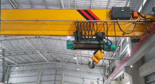 Close up of an overhead crane on a yellow beam wait repair