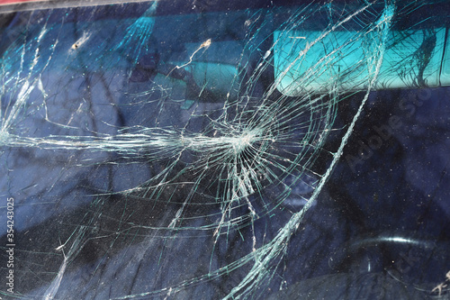 Blurred background of a broken car windshield. Closeup cracks and scratches on a windshield. Horizontal, close-up, free space, cropped shot. Road safety concept.