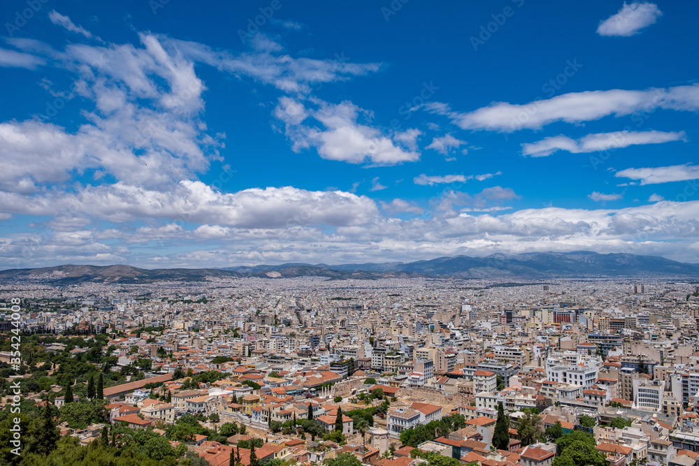 Athens city against blue cloudy sky in a spring day. Aerial view from Acropolis hill. Attica, Greece,