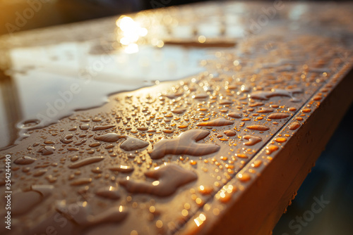 Surface in drops after rain. Droplet of water on wood and sunlight after rain