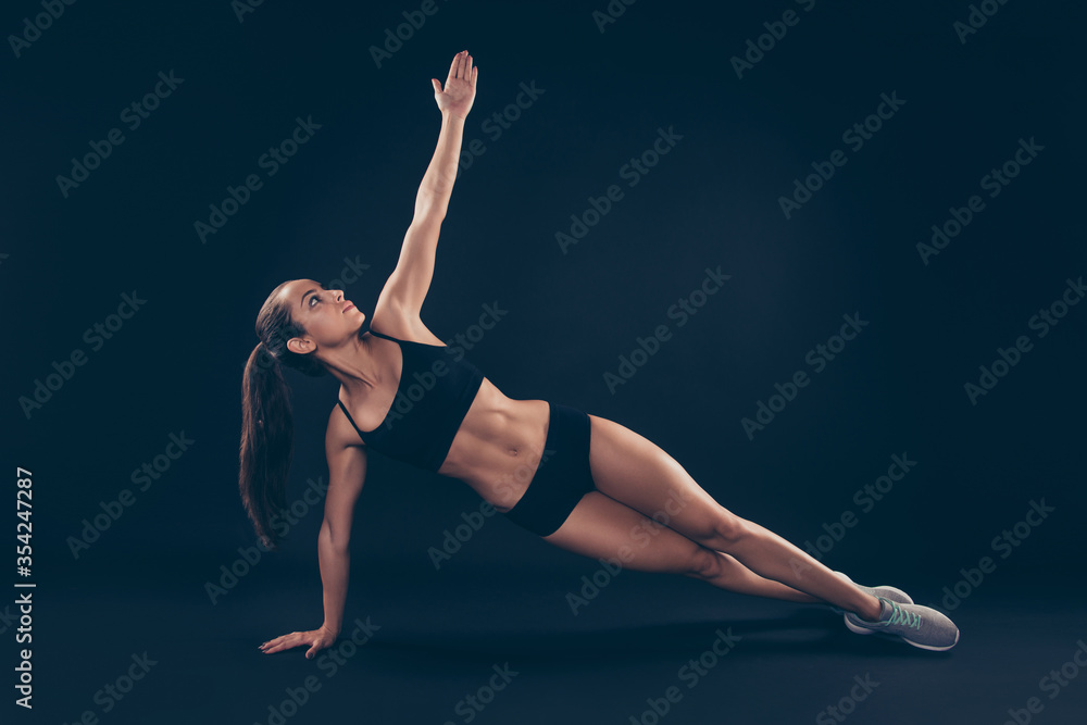 Full size photo short sport suit lady doing side plank determination raise hand up isolated black dark background