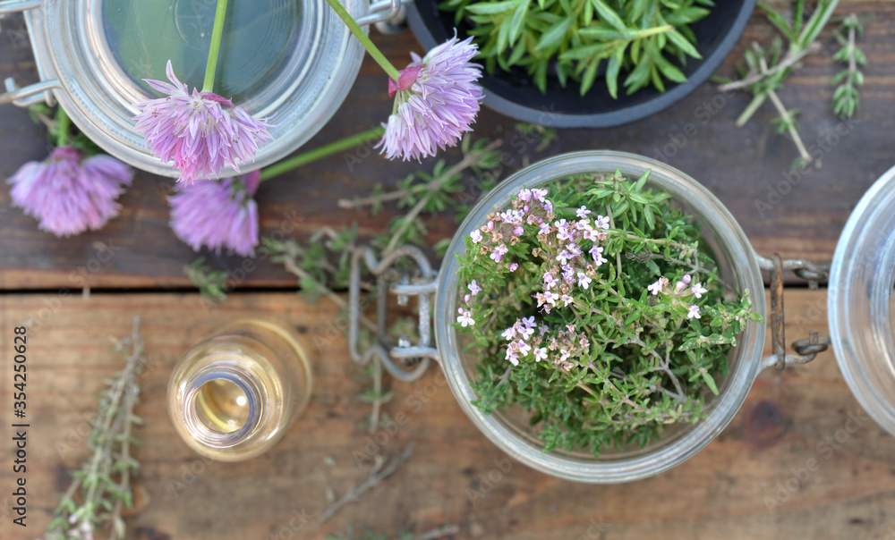 top view on glass jar full of aromatic herb and oil bottle on wooden table top view on glass jar full of aromatic herb and oil bottle on wooden table