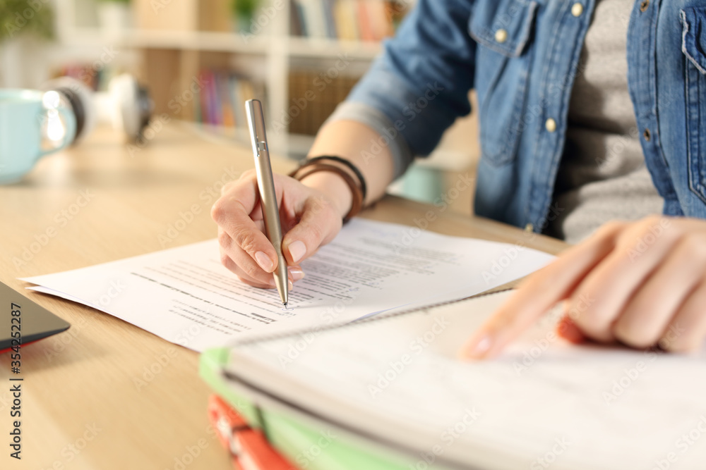 Student girl hand doing exam checking notebook Student girl hand doing exam checking notebook