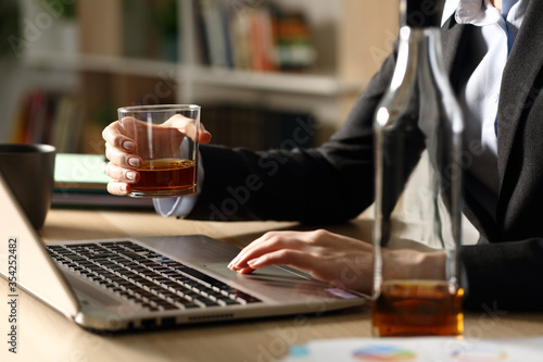 Foto Entrepreneur hands drinking alcohol working on laptop at homeoffice