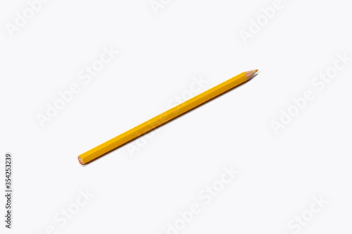The yellow pencil lies diagonally on a white background. Isolate