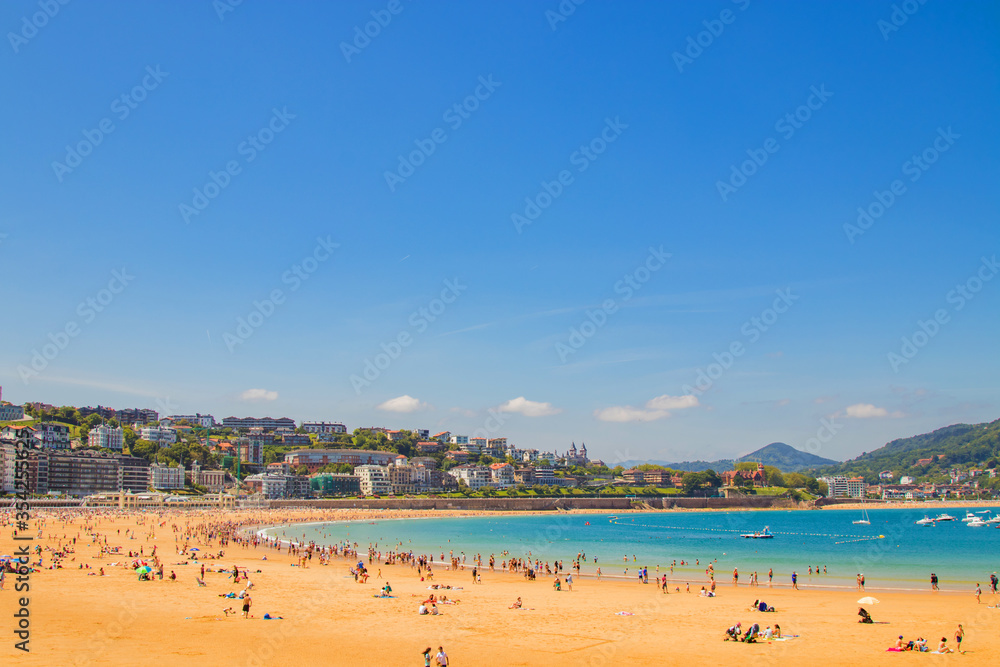 Fototapeta premium SPAIN, SAN SEBASTIAN, JUNE, 16, 2019 - People playa de La Concha beach of the Atlantic Ocean, San Sebastian, Donostia, Spain