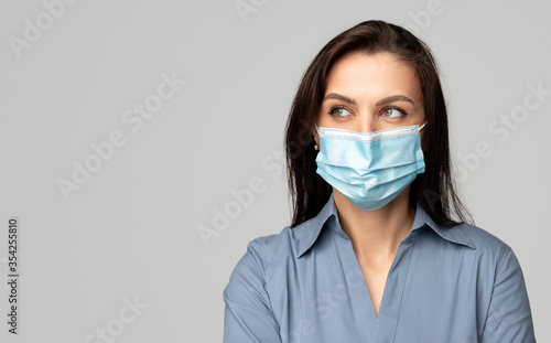 Woman in surgical mask looking away