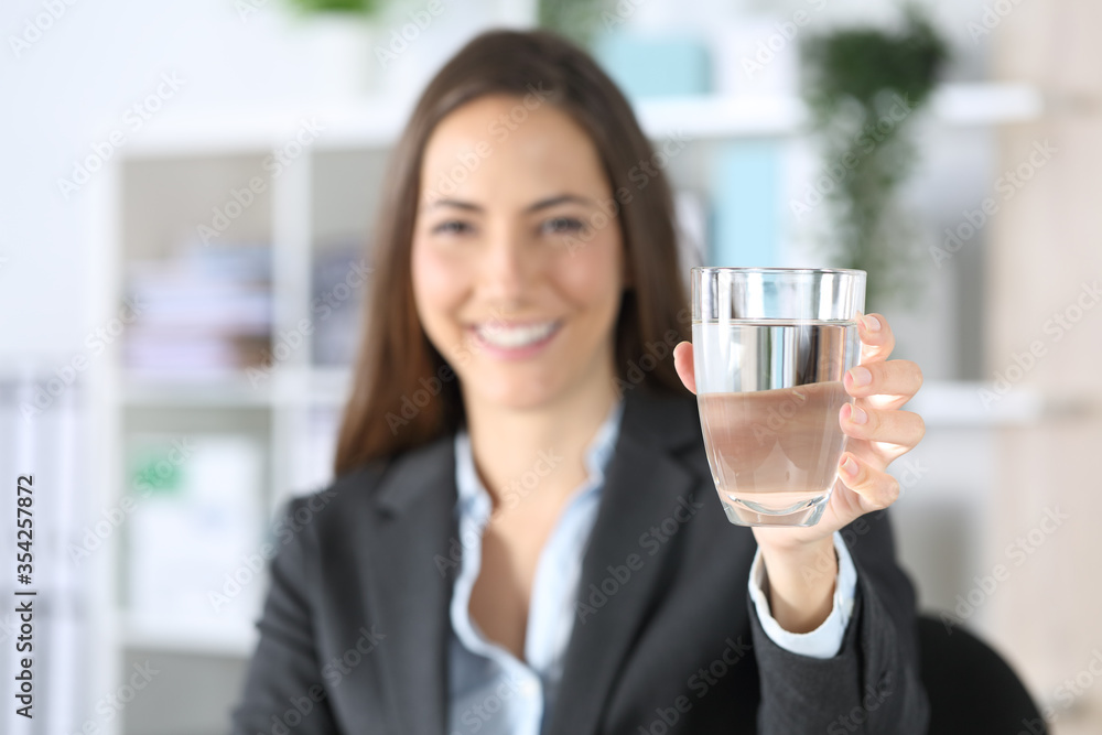 Happy executive showing a glass of water at office Happy executive showing a glass of water at office