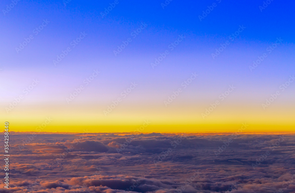 Panorama view of fluffy clouds on sunset sky view from flying airplane Panorama view of fluffy clouds on sunset sky view from flying airplane