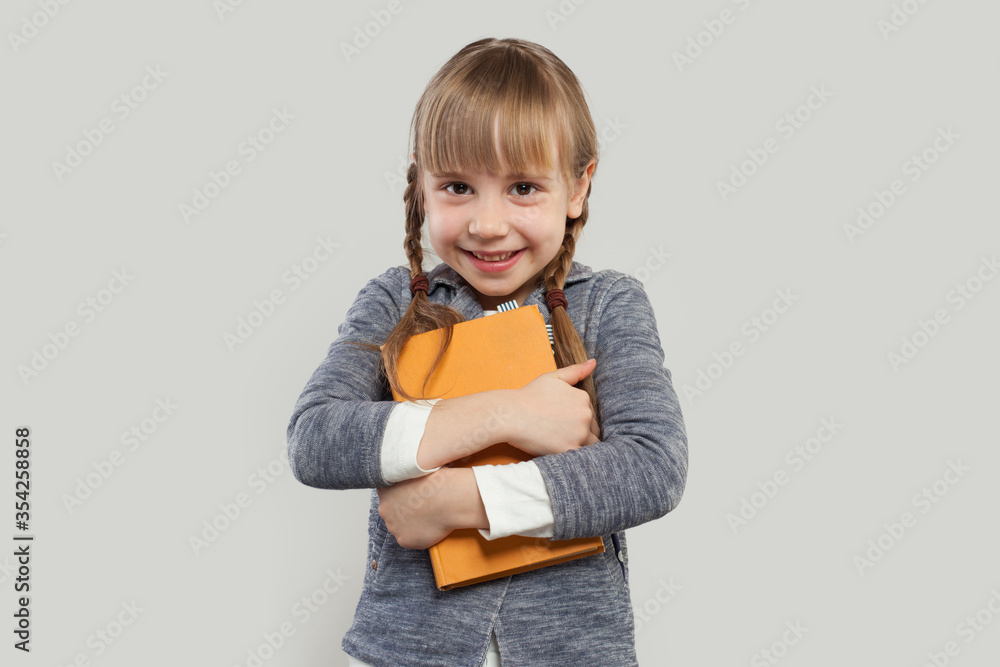 Child girl smiling and embracing book on white Child girl smiling and embracing book on white
