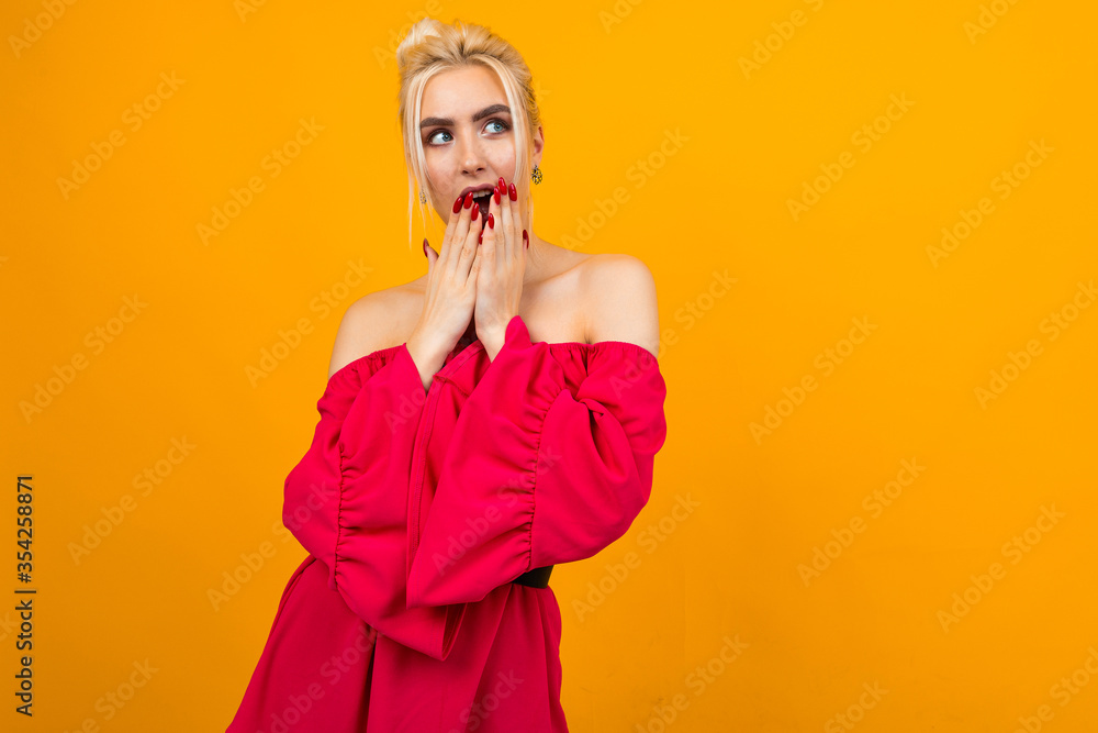 sexy smiling blonde girl in a red dress posing for advertising vacation packages on a yellow studio background sexy smiling blonde girl in a red dress posing for advertising vacation packages on a yellow studio background