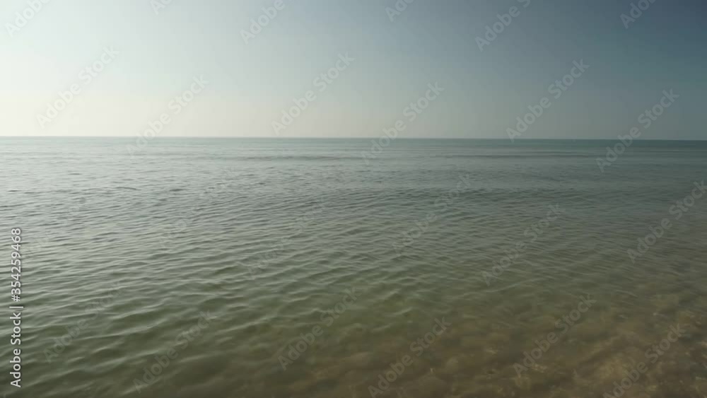 Sea view on the nice summer day. Sea surface close up shot, blue sky with small clouds, clear horizon, nobody. Beautiful summer background for resort and vacation websites. Sea view on the nice summer day. Sea surface close up shot, blue sky with small clouds, clear horizon, nobody. Beautiful summer background for resort and vacation websites.