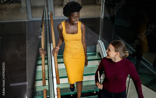 Two diverse businesswomen talking together on some office stairs