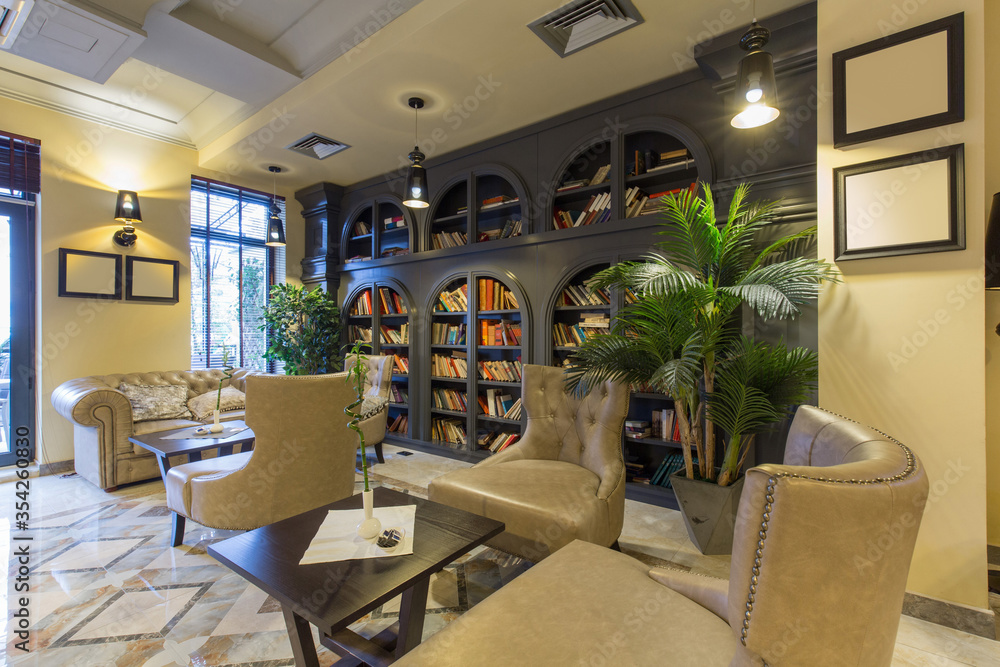 Obraz premium Interior of a hotel lounge with leather furniture and bookshelf