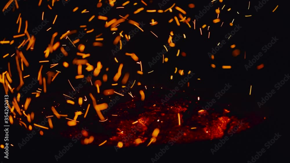 Smoldering bonfire. Close-up of flying sparks on a black background. Fire flames and sparks Smoldering bonfire. Close-up of flying sparks on a black background. Fire flames and sparks
