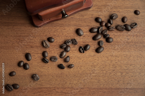 Vintage coffee grinder and coffee beans on brown background