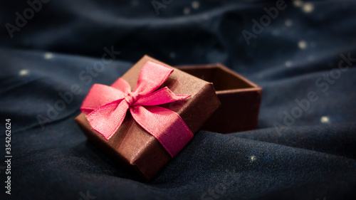 Gift box on a dark background. Festive background, magic box with a gift, surprise.