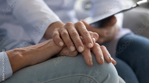 Cuadro en lienzo Close up image, female nurse holding hand of elderly woman patient provides prof