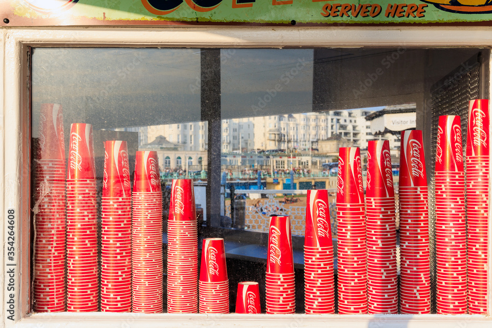 Coca Cola paper cups on display window of a kiosk on the Brighton Pier ...