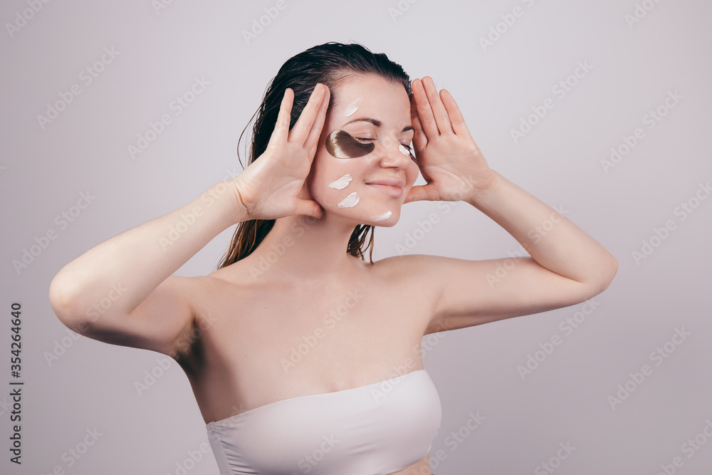 Young beautiful girl looking happy with eye patches on her face, problem dark circles under the eyes Young beautiful girl looking happy with eye patches on her face, problem dark circles under the eyes