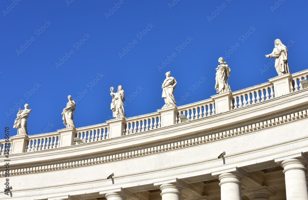 Bernini’s Colonnade and statues at St. Peter’s Square with blue sky. Vatican City, Rome, Italy.