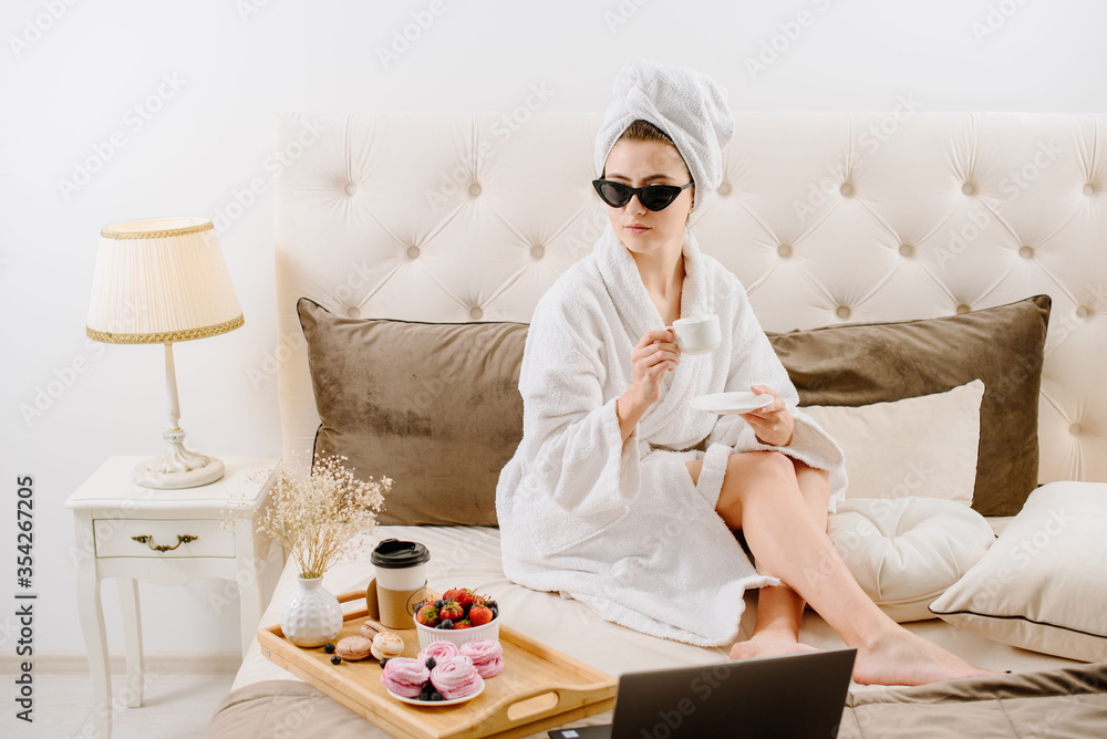 Woman in bathrobe after shower relaxing on the bed at home Woman in bathrobe after shower relaxing on the bed at home